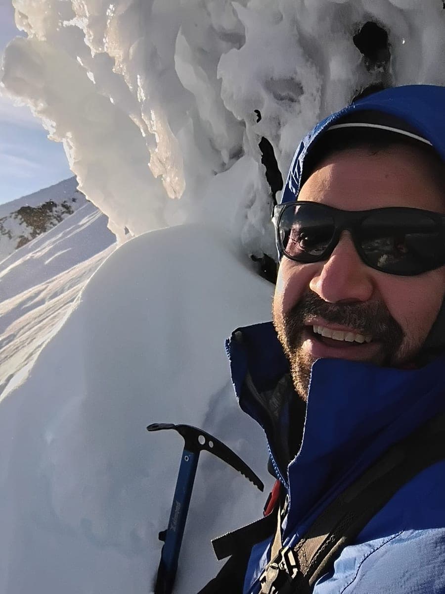 Jonathan Paredes en una cumbre invernal junto a penitentes de nieve